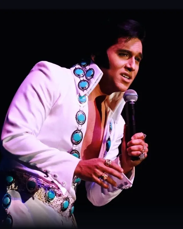 Cote Deonath performing in a white stage jumpsuit