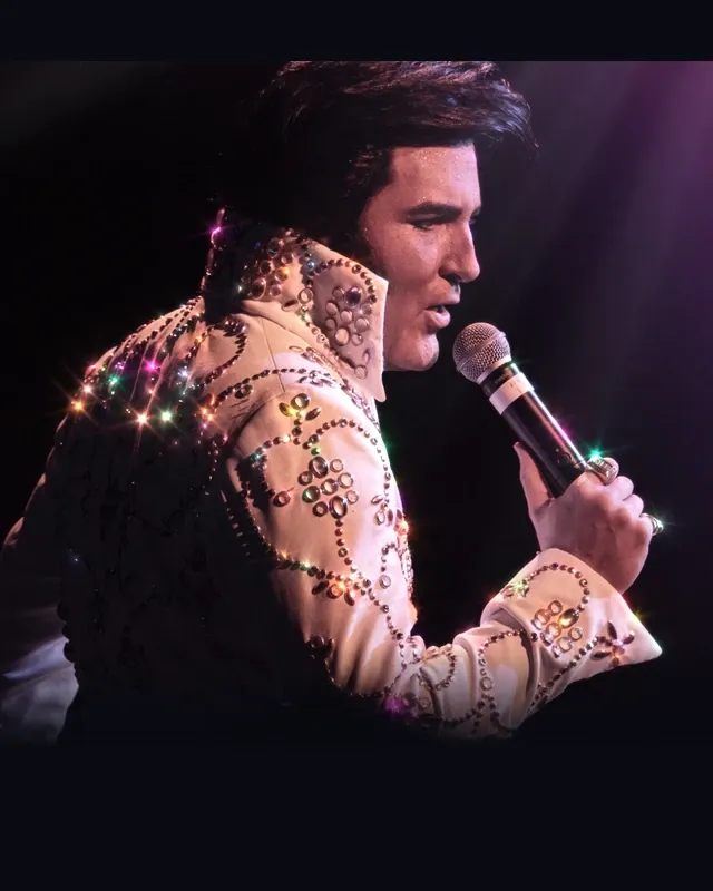 Dwight Icenhower performing in a white stage jumpsuit