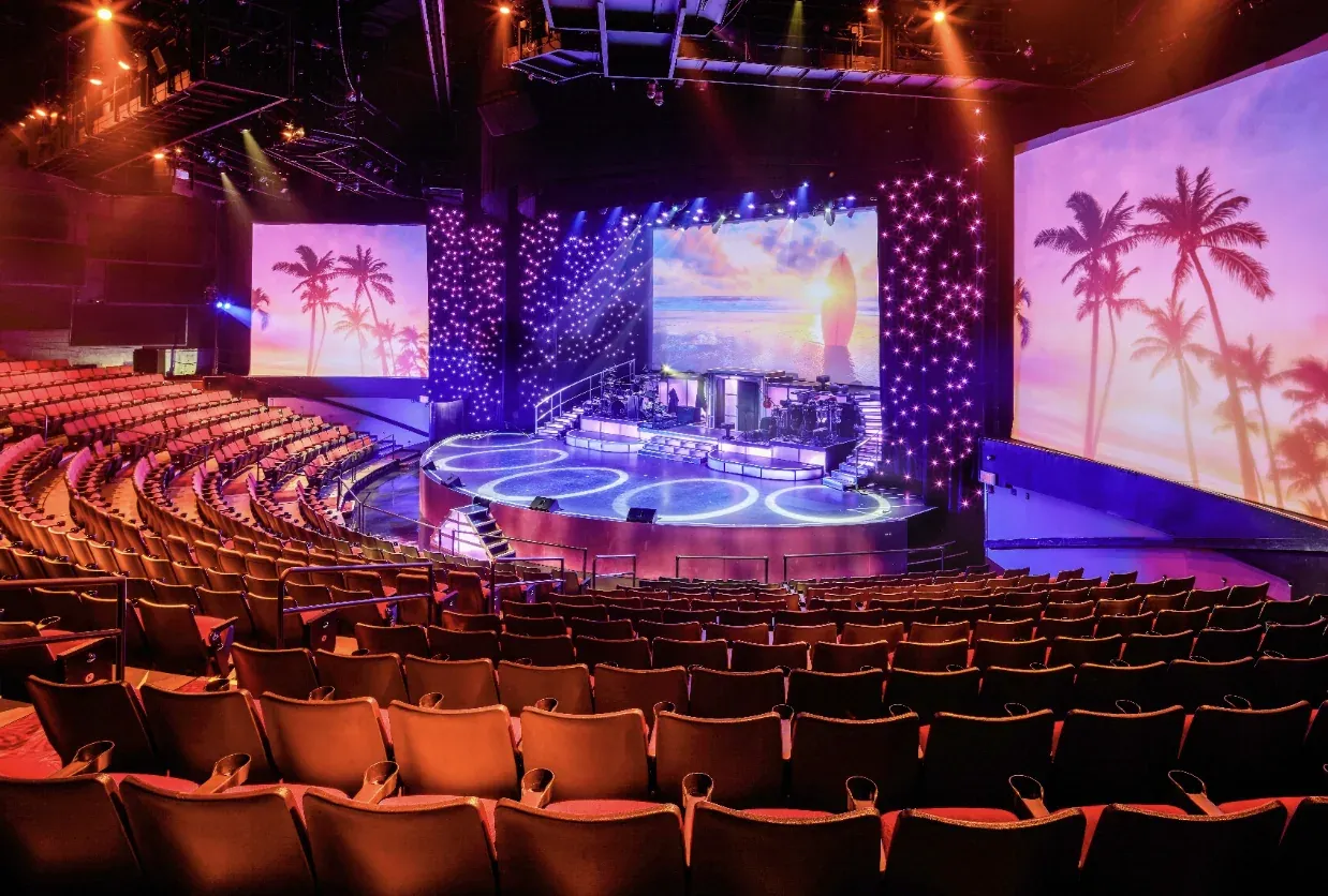 Rock-A-Hula theater with red seating facing a brightly lit tropical stage